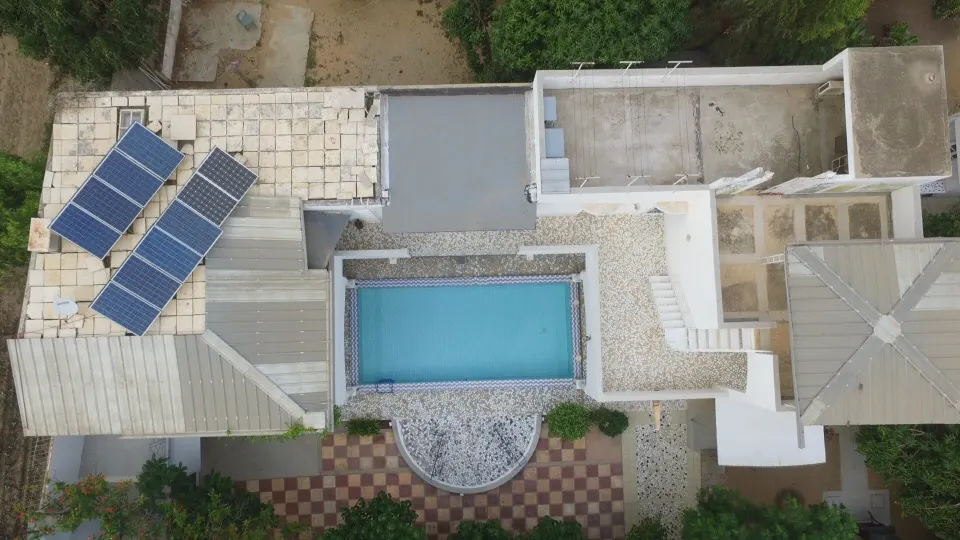 Vue du dessus : piscine, toits et panneaux solaires