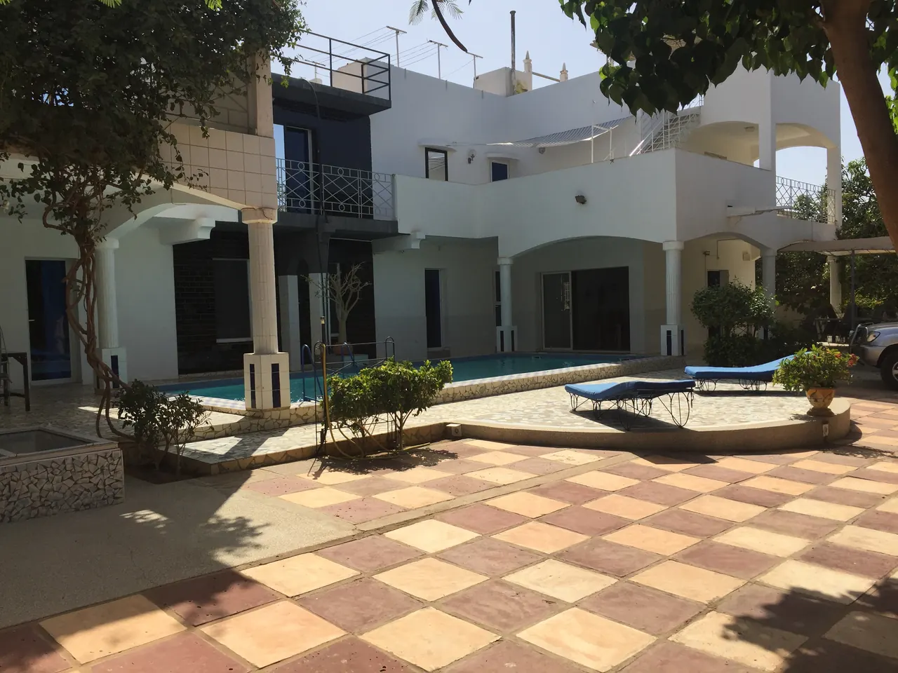 Cour carrelée avec la piscine et les bains de soleil