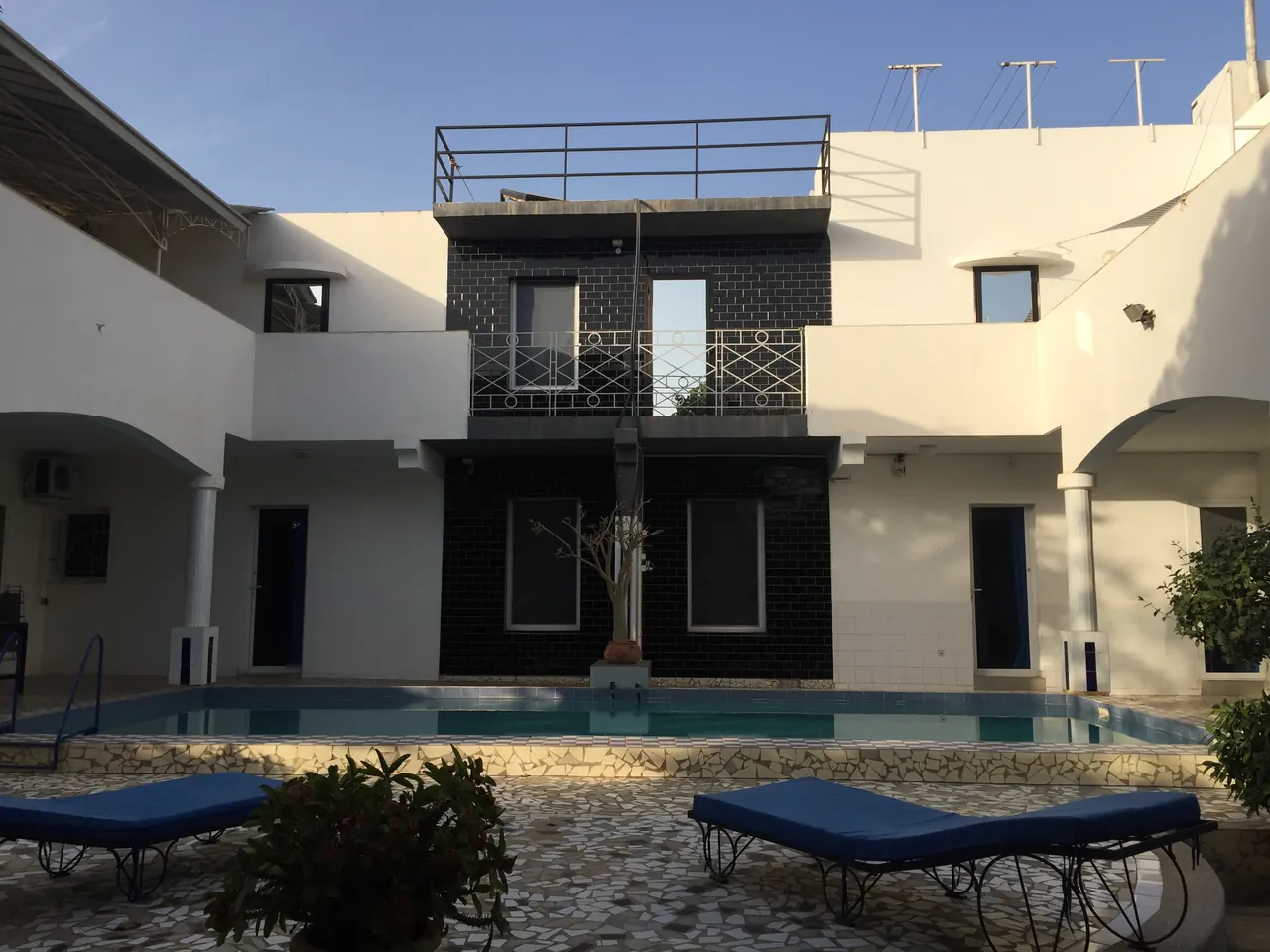 Façade et piscine avec transats bleus