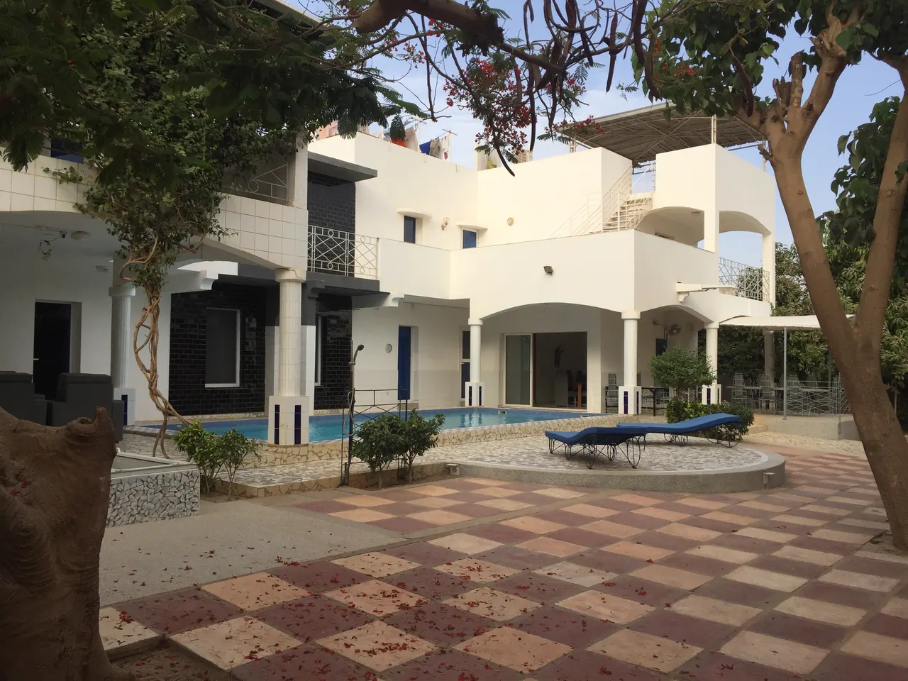Façade de la villa et piscine vues de la cour