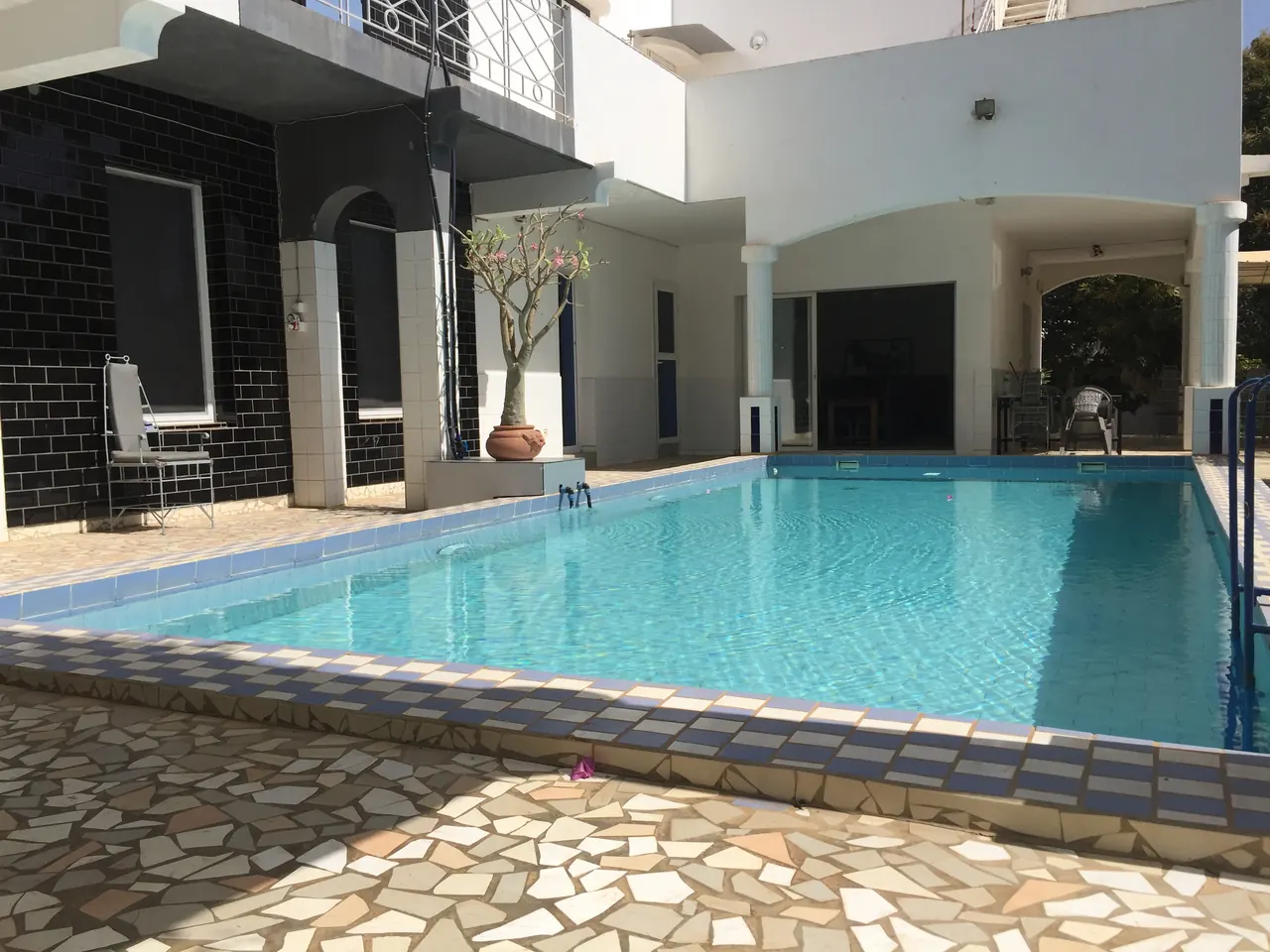 Piscine carrelée devant la façade noire et blanche